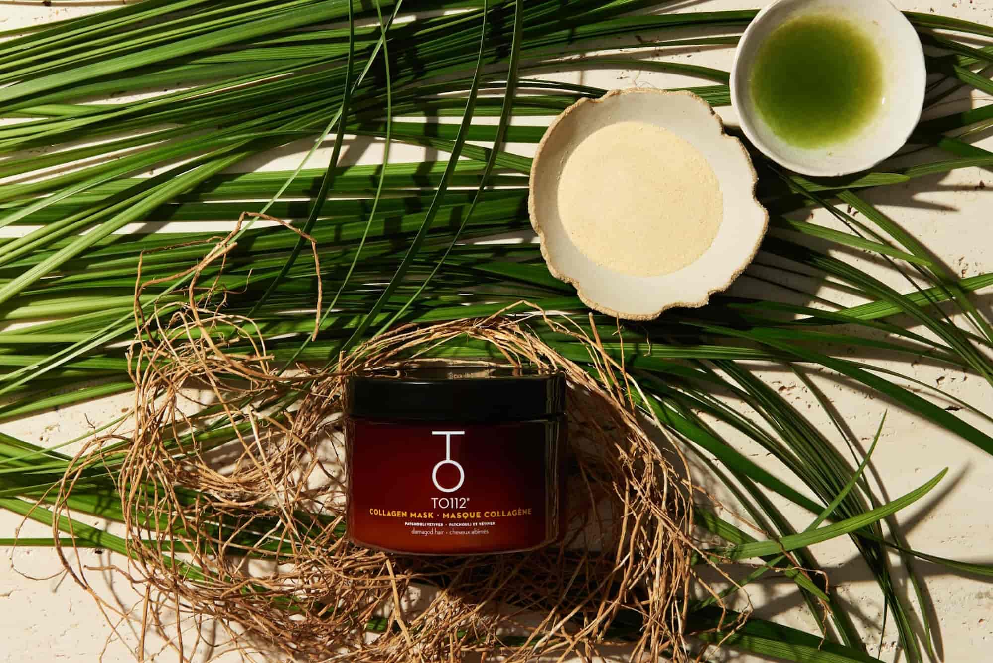 To112 Collagen Mask on a bed of vetiver and patchouli next to a bowl of collagen powder and green tamanu oil.