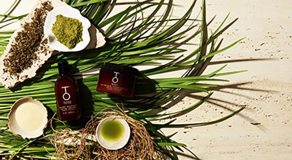 To112 Biotin shampoo for damaged hair and collagen mask on top of grass with ingredients around it